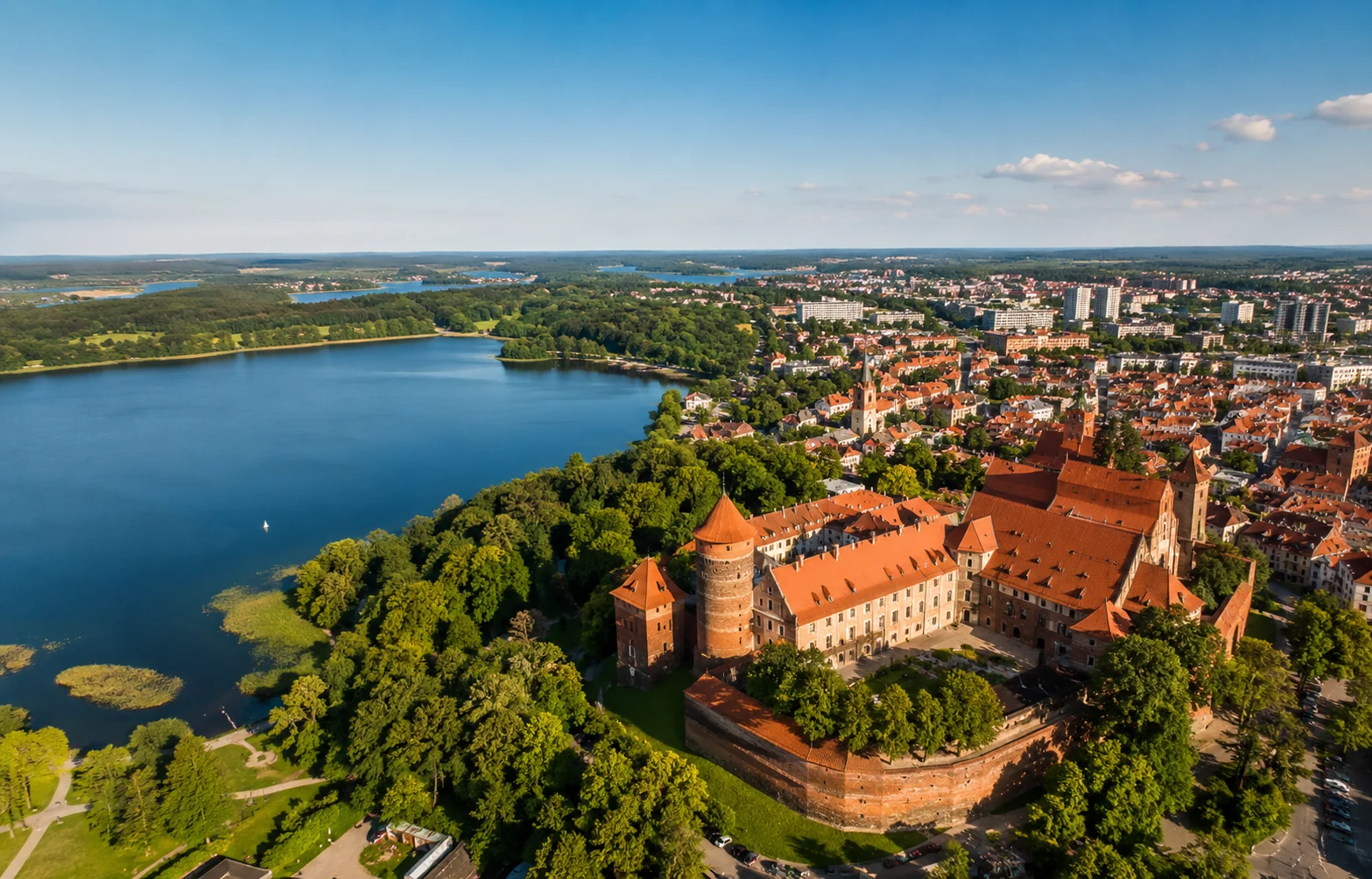 Zdjęcie z drona pokazujące Olsztyn, jezioro i zabudowę miasta