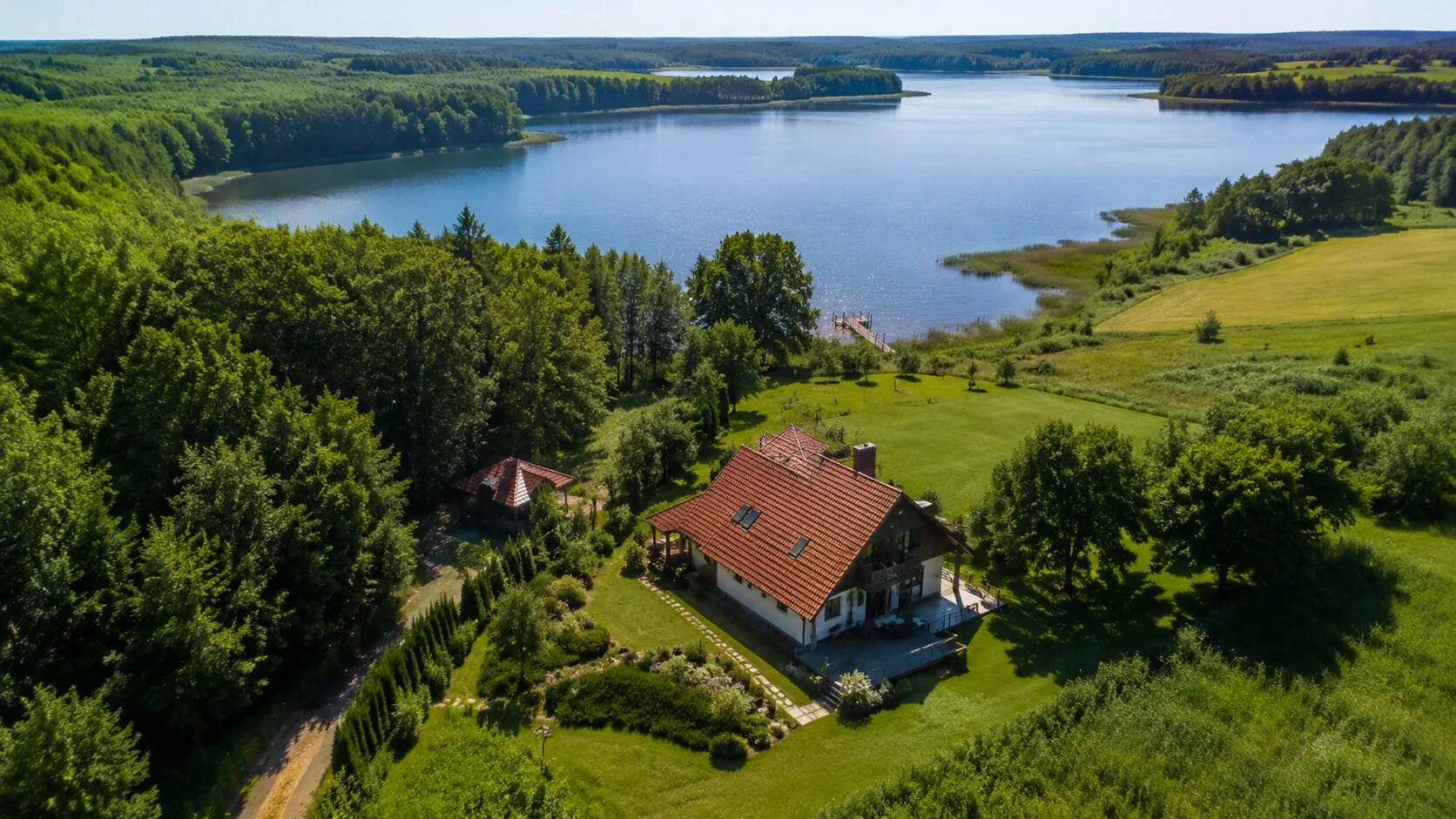 Zdjęcie z drona pokazujące dom nad jeziorem i otoczenie nieruchomości